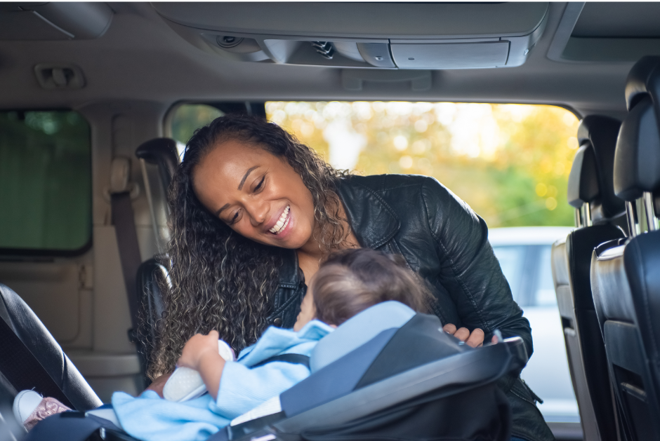 A depiction of a Virginia resident buckling their child into an approved child safety seat.